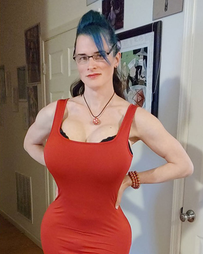 High school teacher in a red costume posing indoors, sparking controversy among parents over outfit choice. High school teacher in a red costume posing indoors, sparking controversy among parents over outfit choice.