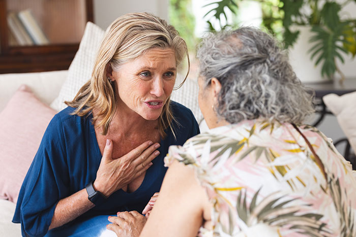 Middle-aged woman upset, confronting older woman about family issues after premature birth in a home setting.