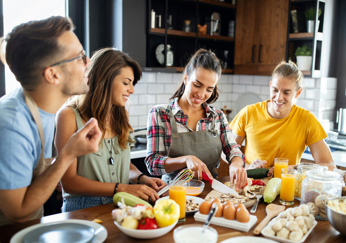 Family cooking together in a kitchen with a husband, woman, and others preparing food for a picky eater with allergies. Family cooking together in a kitchen with a husband, woman, and others preparing food for a picky eater with allergies.