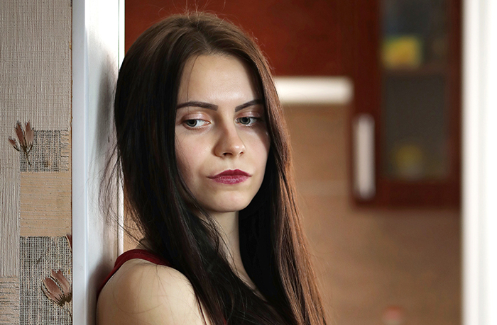 Teen girl with long dark hair looking thoughtful and concerned, wondering about missing $30k, indoors near a wall. Teen girl with long dark hair looking thoughtful and concerned, wondering about missing $30k, indoors near a wall.