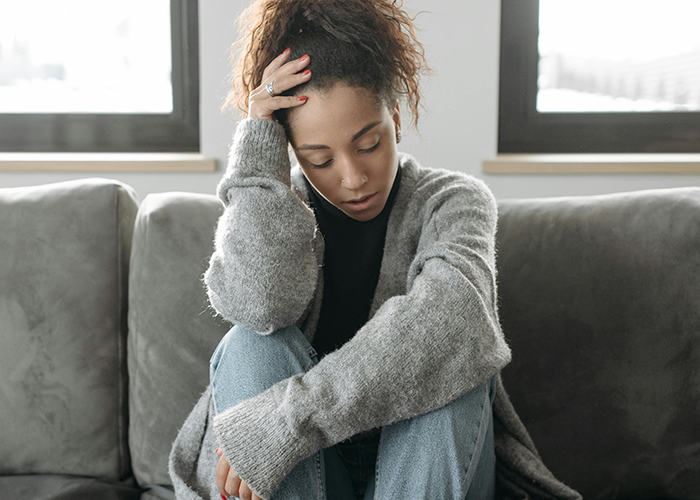 Woman hosting casual Christmas looking stressed while sitting on couch, dealing with toxic mother-in-law conflict. Woman hosting casual Christmas looking stressed while sitting on couch, dealing with toxic mother-in-law conflict.