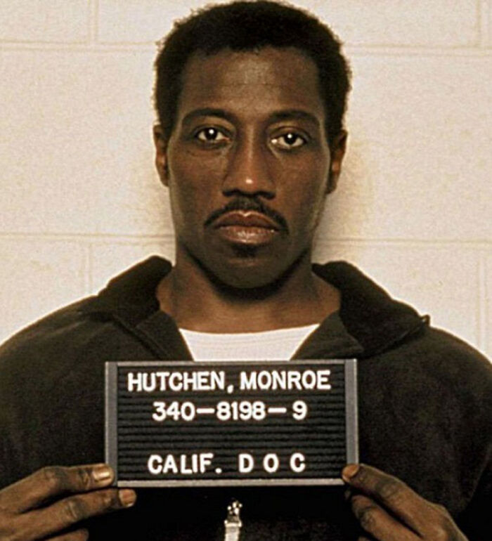 Monroe Hutchen holding a mugshot board in a classic celebrity mugshots photo revealing reasons for arrest.
