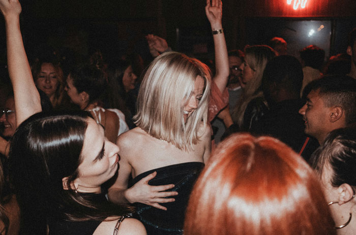 A group of kids dancing and having fun in a crowded party, capturing next-level evil behavior vibes.