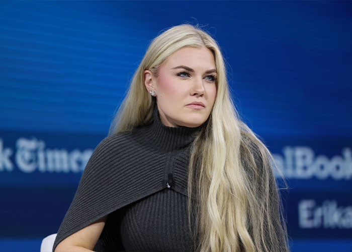 Erika Kirk with long blonde hair and gray outfit speaking at an event, related to husband Charlie's body slammed clip. Erika Kirk with long blonde hair and gray outfit speaking at an event, related to husband Charlie's body slammed clip.