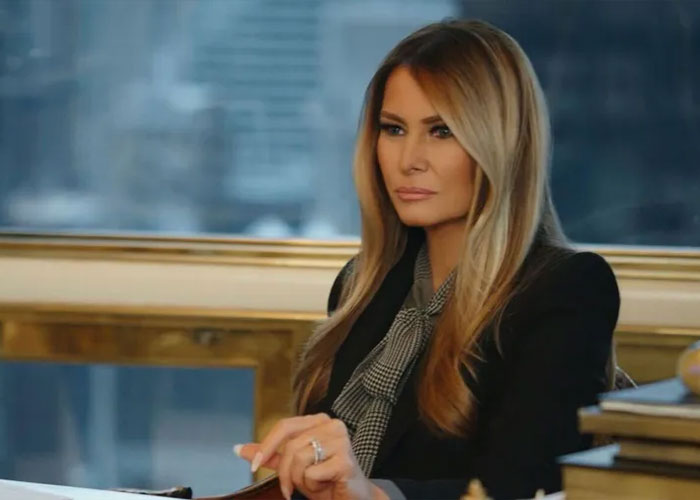 Melania Trump sitting at a desk with a serious expression, featured in her new documentary discussion. Melania Trump sitting at a desk with a serious expression, featured in her new documentary discussion.