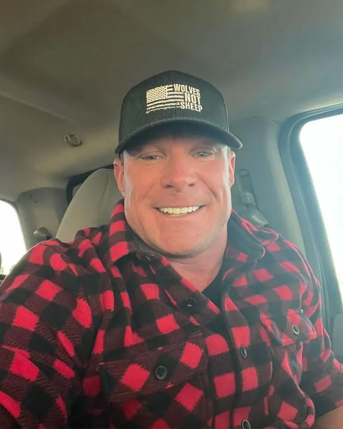 Man in a red and black plaid shirt and hat smiling inside a vehicle, linked to patient's haunting final post before fatal dental procedure