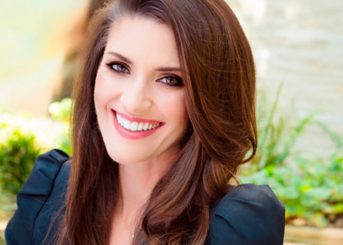 Smiling woman with long brown hair and black top outdoors, representing publicist quitting Meghan Markle and Prince Harry team. Smiling woman with long brown hair and black top outdoors, representing publicist quitting Meghan Markle and Prince Harry team.