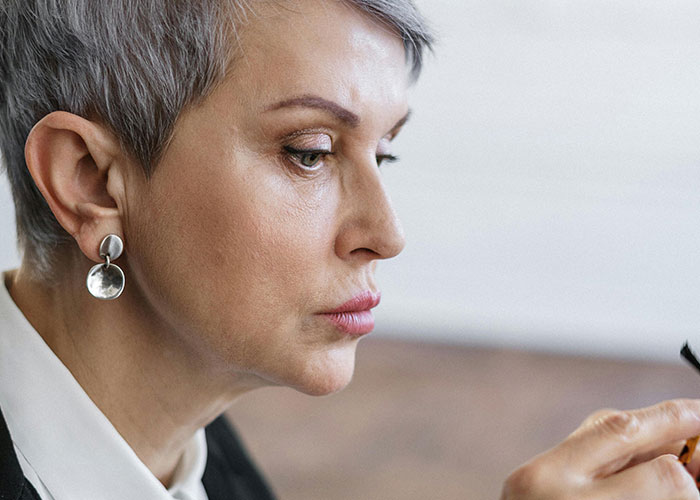 Older woman with gray hair looking serious, representing shock from unhinged things a mother-in-law said to them.