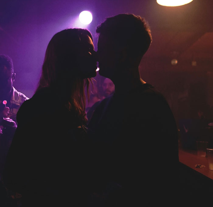 Silhouetted couple close together in a dimly lit setting, depicting couples revealing toughest things they chose to forgive.