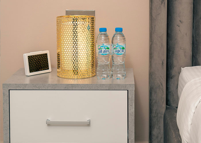 Two water bottles and an ornate lamp on a bedside table, illustrating luxury industry items considered rip-offs.