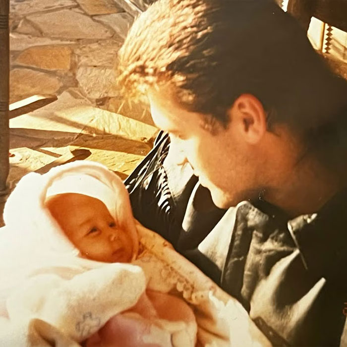 Man holding a newborn baby wrapped in a blanket, representing a woman claiming to be Miley Cyrus true birth mother. Man holding a newborn baby wrapped in a blanket, representing a woman claiming to be Miley Cyrus true birth mother.