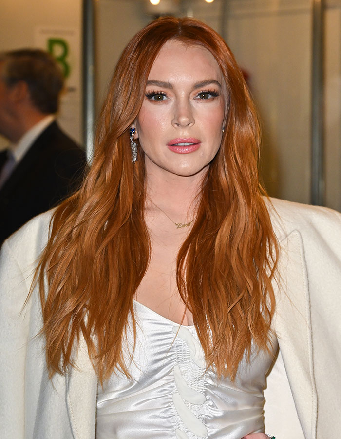 Actress with long red hair wearing a white outfit at an event about outrageous demands actors in contracts.