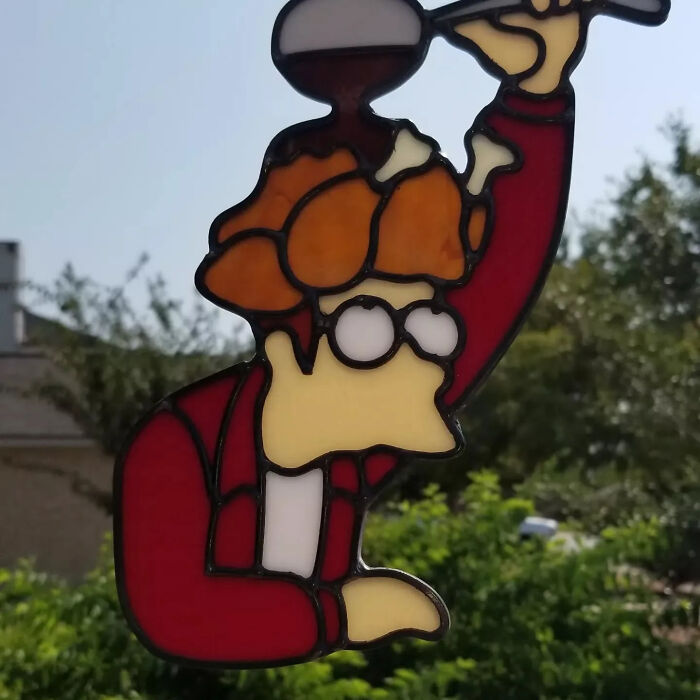 Stained glass art depicting a pop culture icon with vibrant colors and detailed design in an outdoor setting.