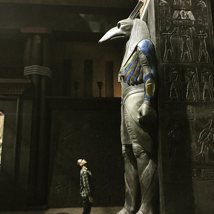 Person looking up at a giant ancient Egyptian statue, an image that can trigger fear in those with megalophobia.