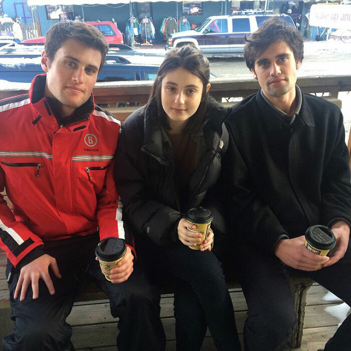 Romy and brother Nick Reiner sitting together outdoors, each holding a coffee cup, showing family moments.