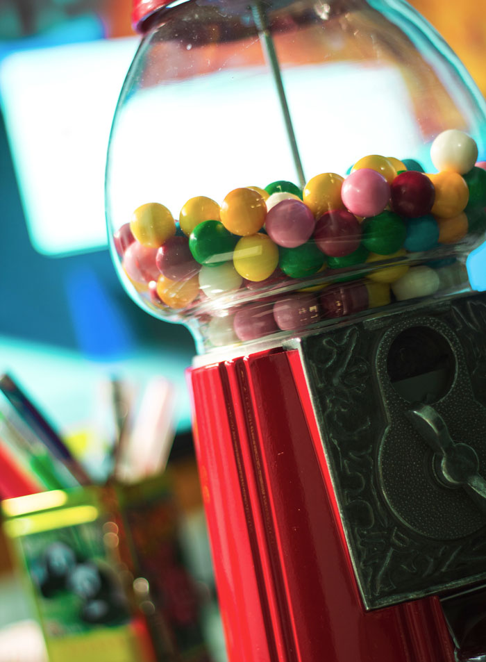Colorful gumballs inside a vintage red white elephant gift machine, a perfect steal for fun holiday gift exchanges.