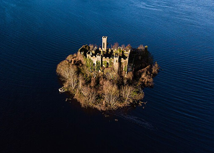 Aerial view of a small island with a historic castle surrounded by water, one of the places that look AI generated but are real.