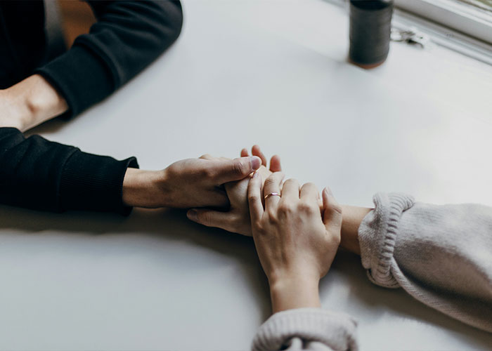Two people holding hands across a table, representing intimate encounters and K-Drama-style dates concept. Two people holding hands across a table, representing intimate encounters and K-Drama-style dates concept.