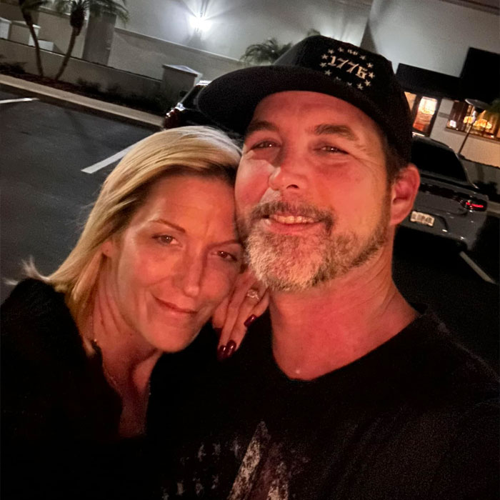 Man and woman posing closely outside at night after heated NFL argument with family, smiling in casual attire. Man and woman posing closely outside at night after heated NFL argument with family, smiling in casual attire.