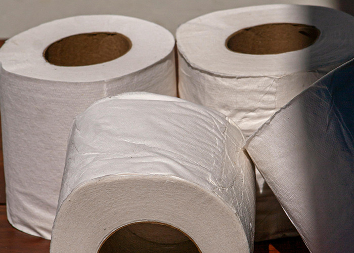 Four rolls of white toilet paper arranged closely, illustrating 911 operators receiving dumb non-emergency calls.
