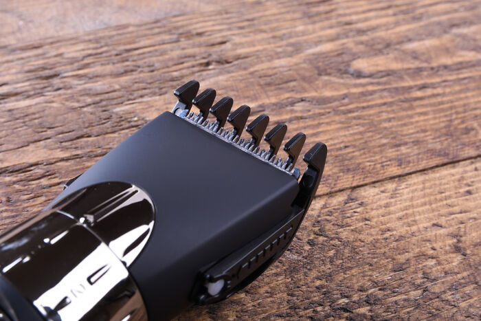 Close-up of a black electric hair clipper on a wooden surface, highlighting grooming tools frequently trusted online.