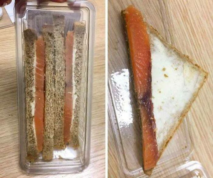 Thin smoked salmon sandwiches with cream cheese on rye bread in a plastic container, Eastern Europe snack humor.
