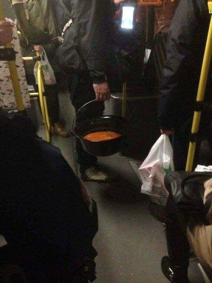 Person carrying a bucket of soup on a crowded bus, capturing a funny moment relatable to growing up in Eastern Europe.