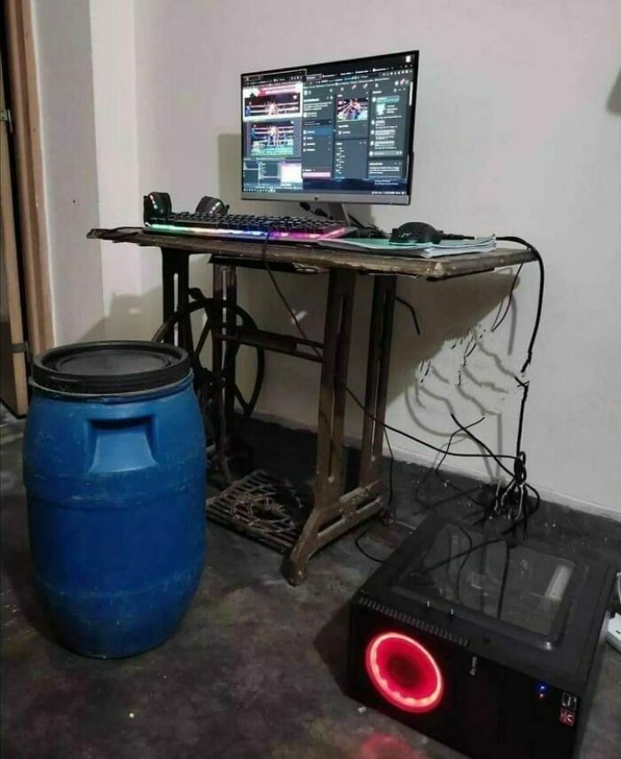 Old sewing machine table converted into a PC setup with a barrel chair, illustrating Eastern Europe humor and memes.