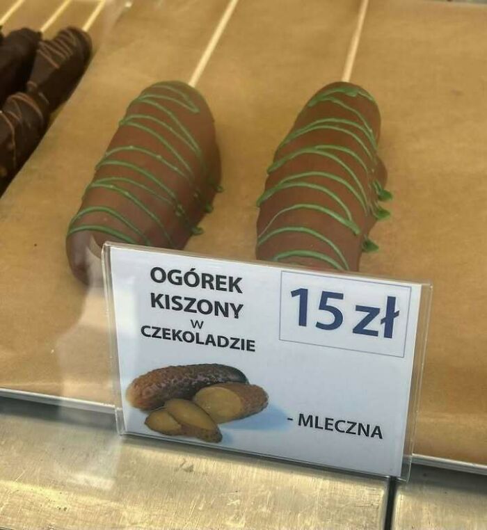 Chocolate-covered pickles displayed with a price tag in a bakery case, a quirky Eastern Europe snack meme.
