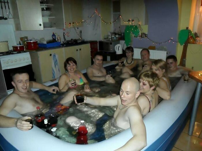 Group of friends in an indoor inflatable hot tub drinking and relaxing, typical Eastern Europe humor and lifestyle moment.
