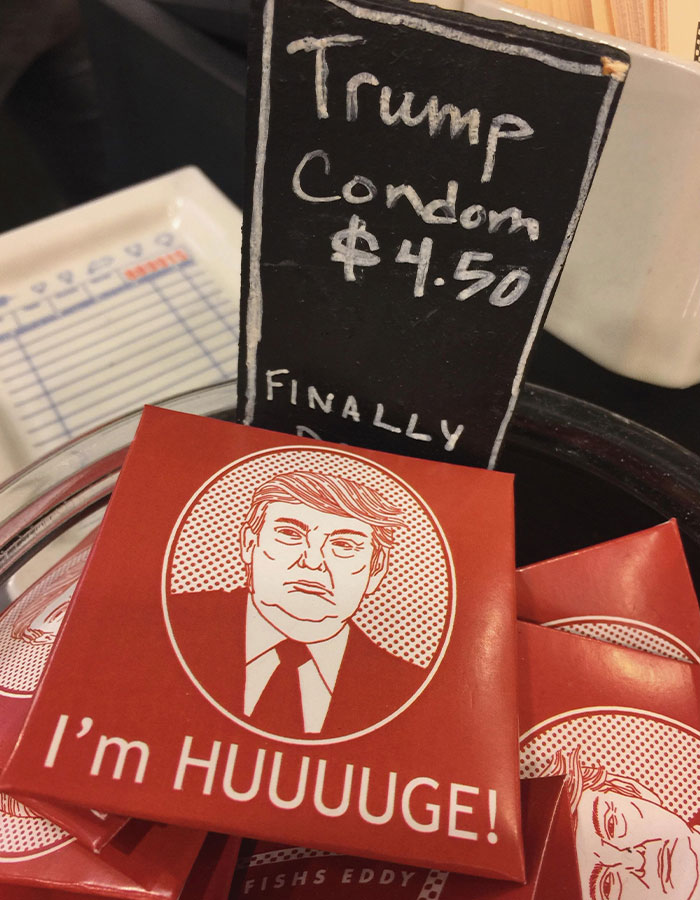 Box labeled I'm HUUUUGE with a cartoon of Donald Trump next to a chalkboard sign in Epstein desk photo estate images.