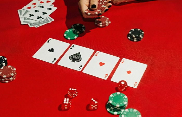 Playing poker with four aces and colorful chips on a red table, showcasing the best party game atmosphere.