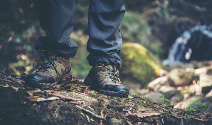 Close-up of hiking boots on a mossy forest floor illustrating people who couldn't sleep after time in the woods.