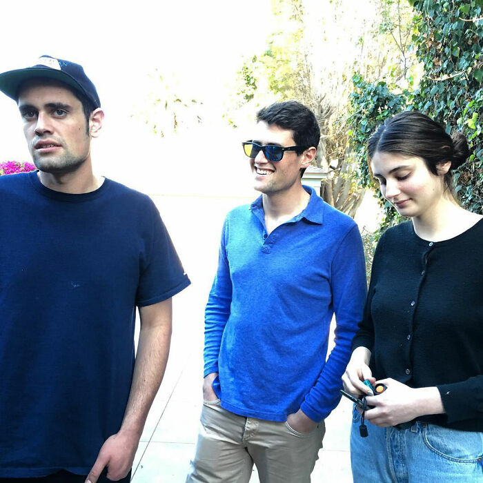 Three young adults outdoors, featuring Rob Reiner&rsquo;s daughter Romy with her brother Nick and another man in casual clothes.
