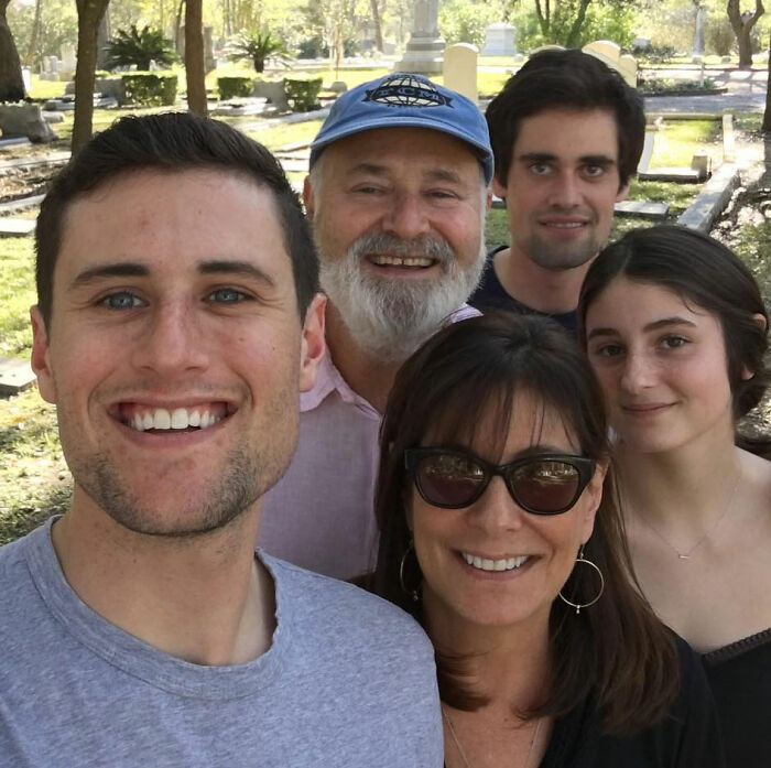 Rob Reiner&rsquo;s son Nick with family outdoors, smiling in casual clothing during a sunny day in a park setting.