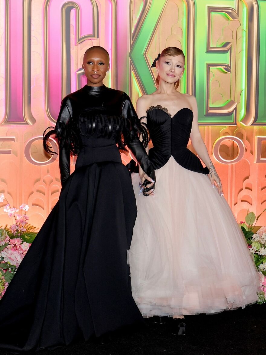 Two fashionably dressed individuals posing together at a colorful event showcasing 2025 pop culture moments.