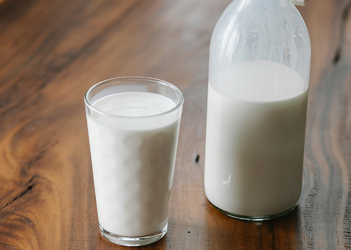 Glass of milk and a bottle on a wooden table, illustrating 911 operators sharing the dumbest non-emergency calls received.