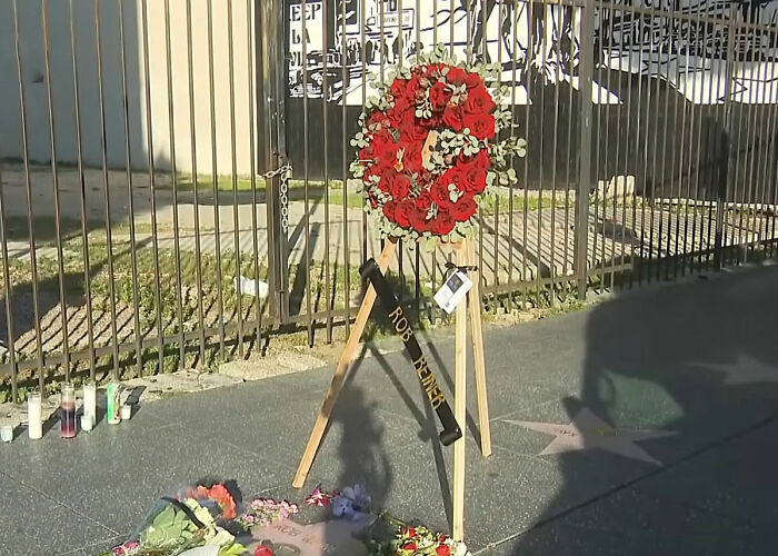 Memorial wreath and flowers near a star on the sidewalk honoring Father Rob amid reports on Nick Reiner's hotel room state. Memorial wreath and flowers near a star on the sidewalk honoring Father Rob amid reports on Nick Reiner's hotel room state.