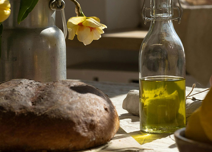Rustic bread and olive oil on a table, illustrating luxury industry products that the rich may consider rip-offs.