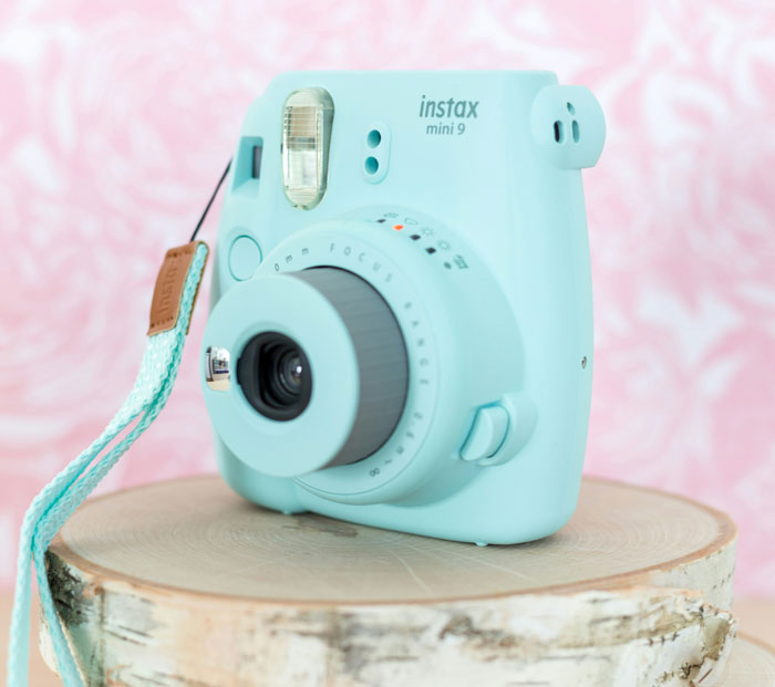 Light blue instant camera displayed as a popular white elephant gift that everyone tried to steal.
