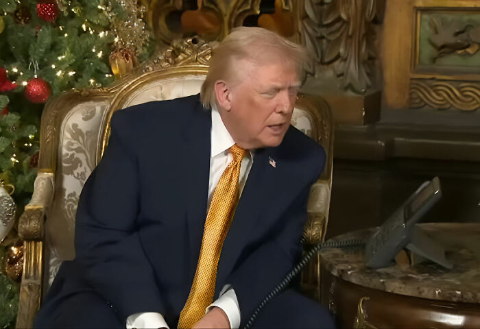 Donald Trump sitting in an ornate chair near a decorated Christmas tree, speaking on a phone about bad Santa comments. Donald Trump sitting in an ornate chair near a decorated Christmas tree, speaking on a phone about bad Santa comments.