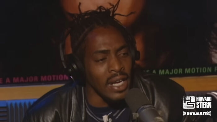 Man speaking into a microphone during a podcast about fascinating secrets about celebrities shared by insiders.