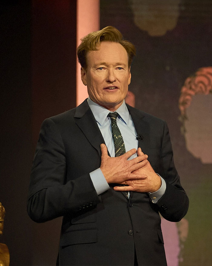 Man in a suit speaking on stage, with a focus on Rob Reiner and son Nick's fight before fatal incident.