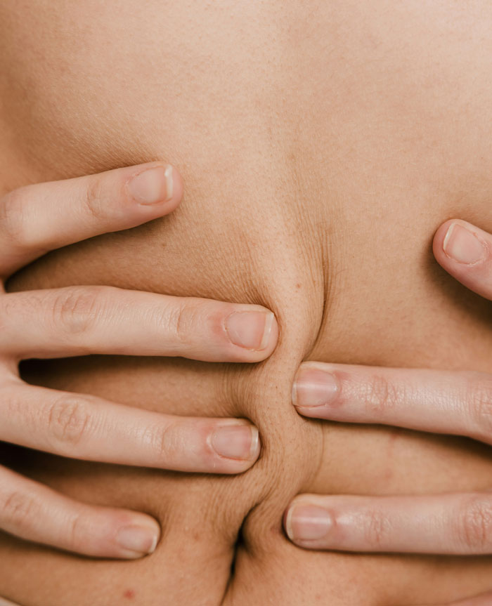 Close-up of fingers pinching skin, illustrating a playful moment related to kids' spicy roasts and funny reactions.