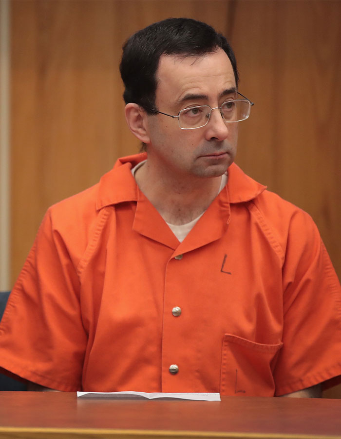 Man in orange prison jumpsuit and glasses sitting in a courtroom, related to Epstein file dump and troubling art evidence.