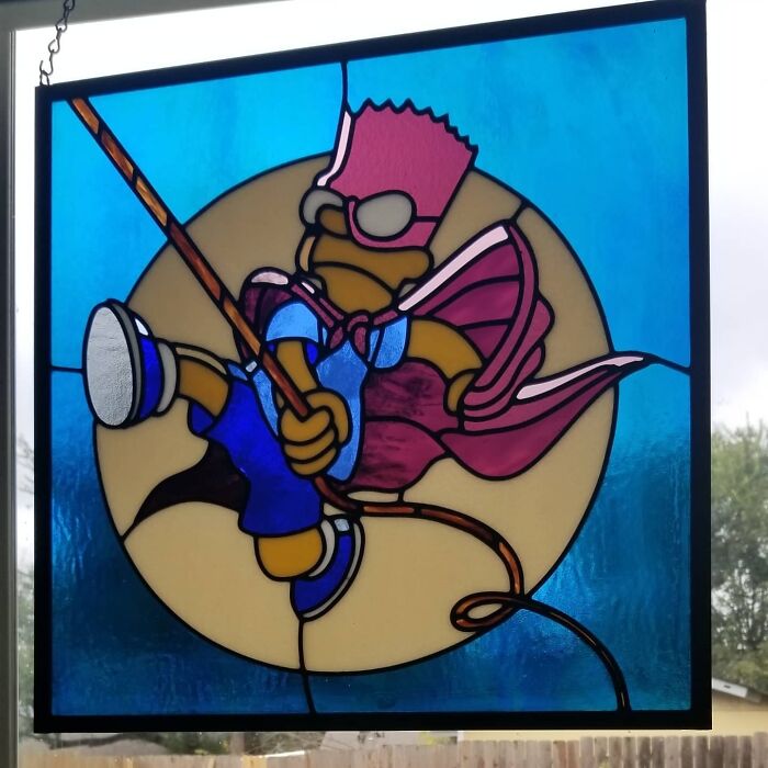 Stained glass art of pop culture icon Bart Simpson dressed as a superhero, set against a blue and beige background.