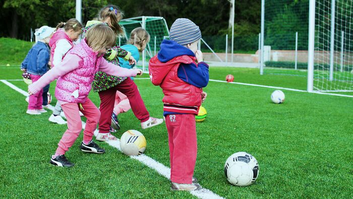 Young children practicing soccer on a field, illustrating ambiguous situations to cast your vote on fault and right.