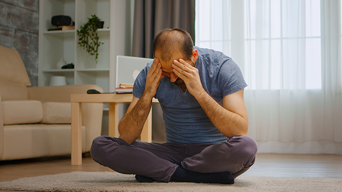 Man sitting on floor holding head in frustration, illustrating struggle with self-diagnosed autism behavior excuses. Man sitting on floor holding head in frustration, illustrating struggle with self-diagnosed autism behavior excuses.