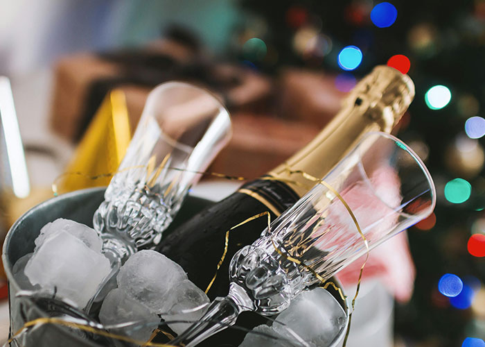 Champagne bottle and crystal glasses chilling on ice, highlighting luxury industry items often seen as rip-offs.