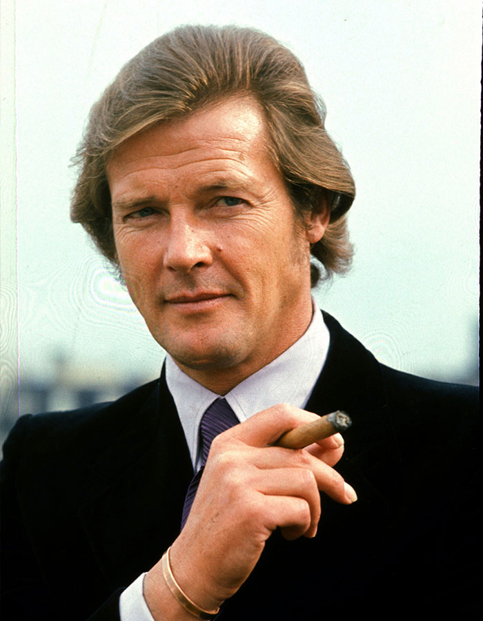 Actor in a suit holding a cigar, representing outrageous demands actors have allegedly put in their contracts.